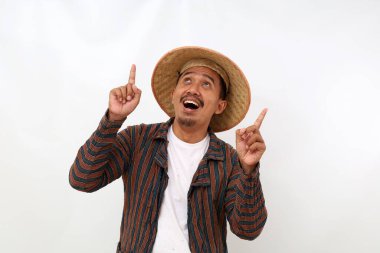 Happy asian farmer standing while pointing something above him. Isolated on white background clipart