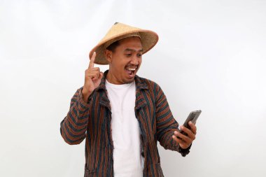 Happy asian farmer standing while getting solution from his phone. Isolated on white background clipart