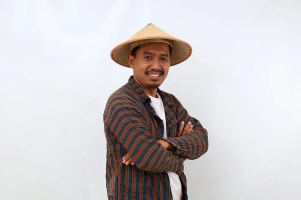 カメラを見ながら帽子をかぶって手を組んで立っている幸せなアジアの農家 白地に隔離された — ストック写真