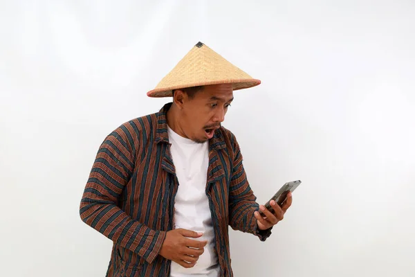 震惊的亚洲农民站在那里从他的手机里获取信息 因白人背景而被隔离 — 图库照片