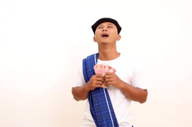 Endonezya parası elinde tutarken mutlu bir Asyalı. Beyazda izole edilmiş. Ramazan kavramı