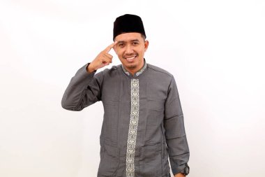 Zeki Asyalı Müslüman bir adam kafasını bir şeye doğrulturken ayakta duruyor. Beyaz arkaplanda izole