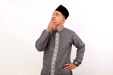 Asyalı Müslüman adam bir fikri hayal ederken ya da düşünürken ayakta duruyor. Beyaz arkaplanda izole