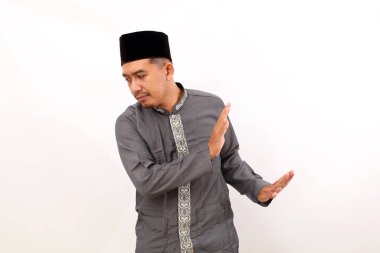 Asyalı Müslüman adam inkar hareketiyle ayakta duruyor. Beyaz arkaplanda izole