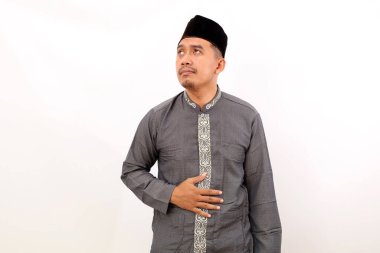 Asyalı Müslüman adam aç hissediyor. Elini karnına koy. Oruç kavramı. Beyaz arkaplanda izole