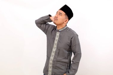 Düşünceli Asyalı Müslüman adam bir fikir düşünürken ayakta duruyor. Beyaz arkaplanda izole