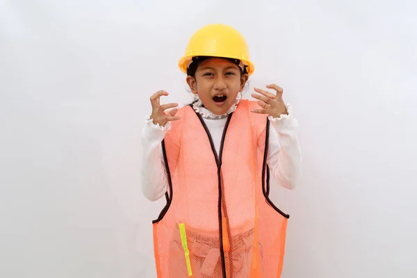 Stressed Asian little girl in the construction helmet as an engineer standing while screaming. Isolated on white