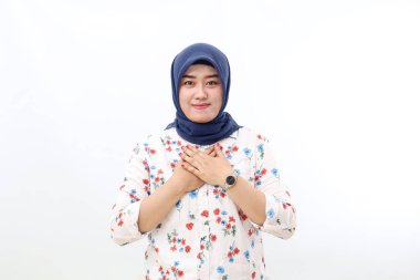 Happy asian veiled woman standing while showing relieved gesture. Isolated on white background