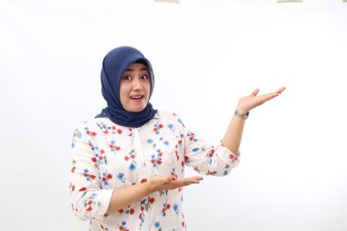 Happy asian veiled woman standing while presenting sideways. Isolated on white background with copyspace