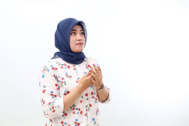 Asian veiled woman standing while praying. Isolated on white background