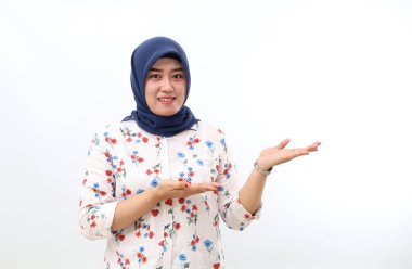 Happy asian veiled woman standing while presenting sideways. Isolated on white background with copyspace