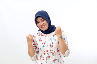 Excited asian muslim woman standing while celebrating her victory. Isolated on white background