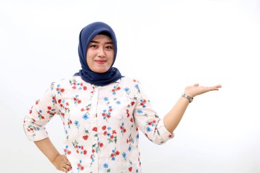Happy asian muslim woman standing while presenting something. Isolated on white background