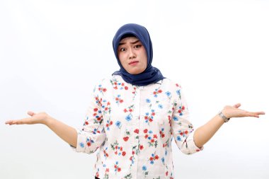 Confused asian muslim woman standing while showing unsure hand gesture. Isolated on white background