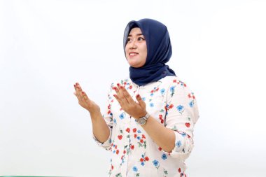 Happy asian muslim woman standing with pray hand gesture. Isolated on white background