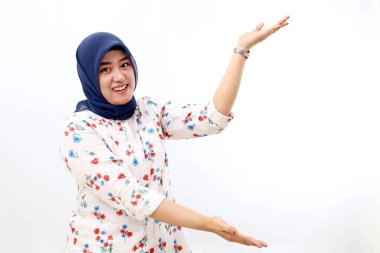 Happy asian muslim woman standing while presenting something sideways. Isolated on white background