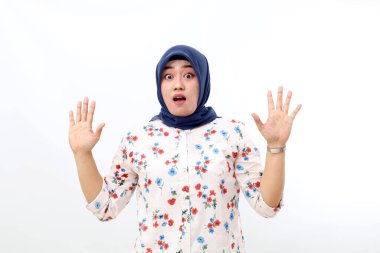 Shocked asian muslim woman standing while lift her hand. Isolated on white background