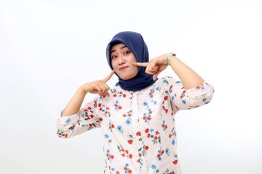 Cheerful asian muslim woman standing while posing and looking at the camera. Isolated on white