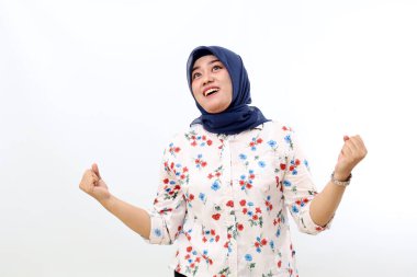 Satisfied asian muslim woman standing while celebrate her victory. Isolated on white background