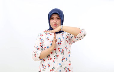Asian muslim woman standing while making time out hand gesture. Isolated on white background