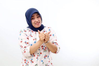Happy asian muslim woman standing while showing thumbs up. Isolated on white background