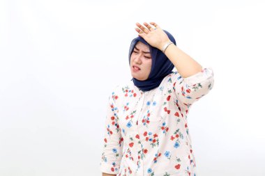 Tired asian muslim woman standing while holding her head. Isolated on white background
