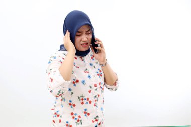 Stressed Asian muslim woman standing while talking on the phone. Isolated on white background