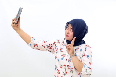 Asian muslim woman standing while photographing her self. Isolated on white background