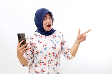 Yan tarafı gösterirken cep telefonu tutan Asyalı Müslüman kadın şaşırdı. Beyazda izole edilmiş