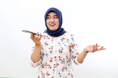 Happy asian muslim woman talking on the phone with loud speaker mode. Isolated on white background