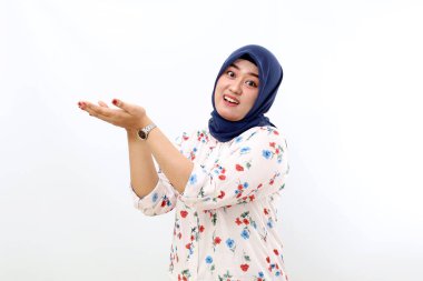 Happy asian muslim woman standing while holding something. Isolated on white background