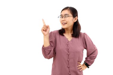 Genç Asyalı mutlu bir kadın dikilirken yan tarafa bakıyor. Beyaz arkaplanda izole