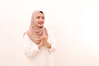 Portrait of beautiful young asian muslim woman standing with welcoming gesture. Isolated on white