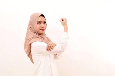 Young asian muslim woman standing with strong gesture. Isolated on white with copyspace
