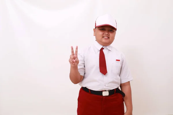 Grundschüler Tragen Rot Weiße Uniform Und Zeigen Zwei Finger Isoliert — Stockfoto