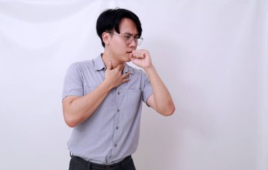 Asyalı adam boğazını tutarken öksürüyor. Beyaz arkaplanda izole
