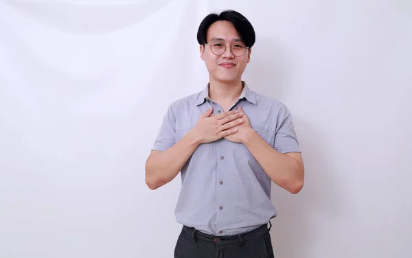 Lättad Asiatisk Man Stående Medan Han Håller Bröstet Isolerad Vitt — Stockfoto