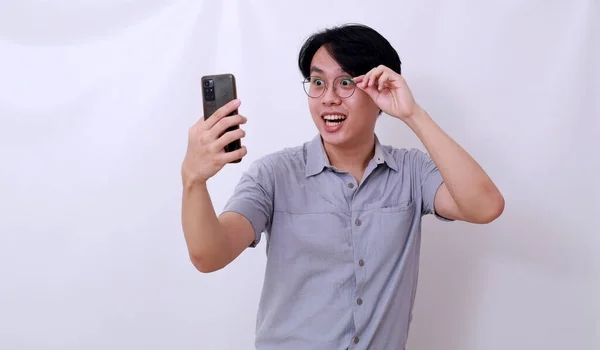 Здивований Азіатський Чоловік Отримує Хороші Новини Свого Телефону Тримаючи Окуляри — стокове фото