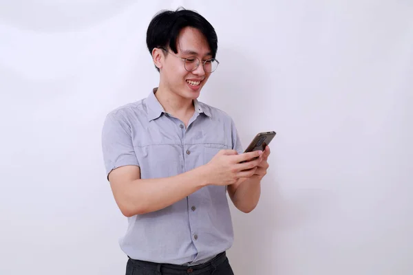 携帯電話を使いながら立っている幸せなアジア人男性 白に隔離された — ストック写真