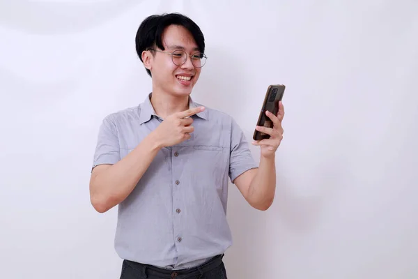 Glad Asiatisk Man Stående När Han Använder Sin Mobiltelefon Isolerad — Stockfoto