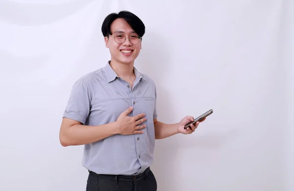 Glad Lättad Asiatisk Man Som Håller Mobiltelefon Medan Han Tittar — Stockfoto