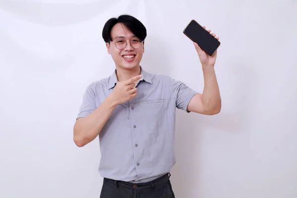 快乐的亚洲男人站在那里 展示着一个空白的手机显示屏 与白种人隔离 — 图库照片