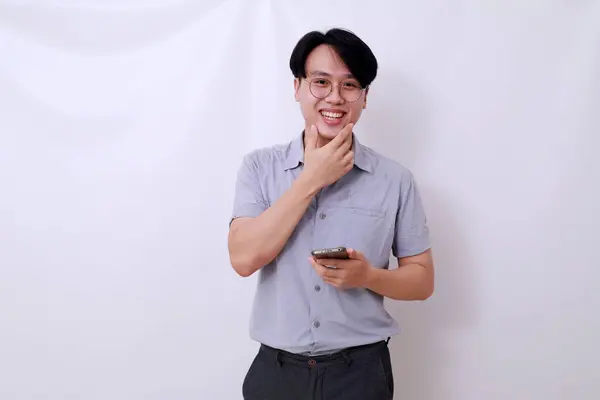 Щасливий Азіатський Чоловік Тримає Мобільний Телефон Дивлячись Камеру Ізольовані Білому — стокове фото