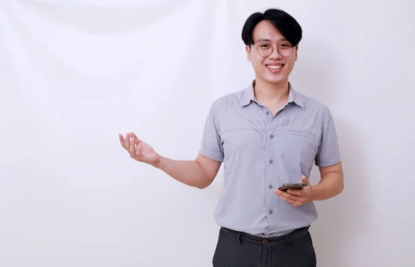 Feliz Asiático Hombre Sosteniendo Celular Mientras Presentando Algo Lado Aislado — Foto de Stock