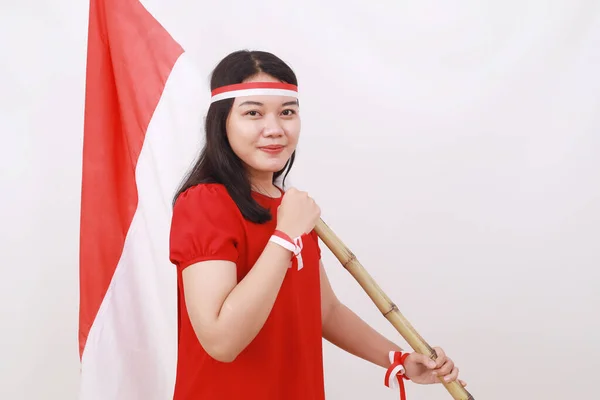 若いですインドネシア人の女の子祝います独立日ながら保持赤い白い旗とともに拳手 — ストック写真
