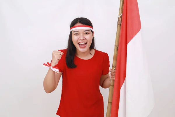 興奮した若いですインドネシアの女の子祝います独立日同時に開催赤ホワイトフラグとともに拳手 — ストック写真