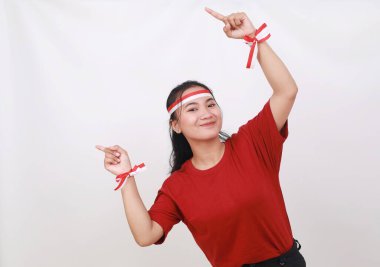 Endonezyalı genç kız, boş uzaya bir şey doğrulturken Endonezya 'nın bağımsızlık gününü kutluyor