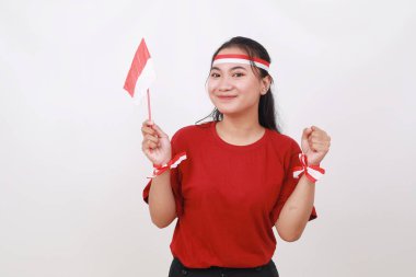 Heyecanlı genç Endonezyalı kız elini sıkarken kırmızı beyaz bayrak tutuyor. Beyazda izole edilmiş