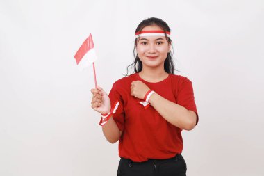 Genç Endonezyalı kız elinde kırmızı beyaz bayrak ve göğsüyle bağımsızlık gününü kutluyor.