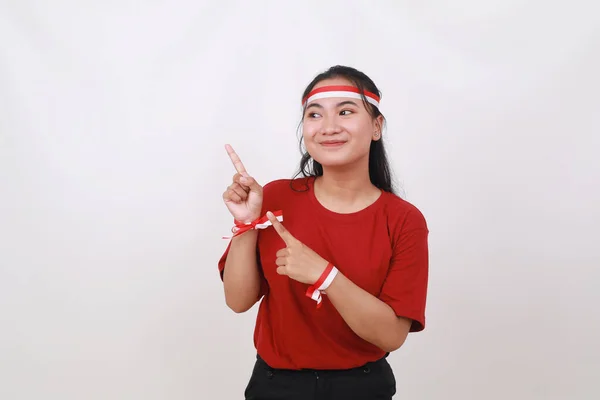年轻的印度尼西亚女孩庆祝印度尼西亚独立日 同时把一些东西指向空白处 — 图库照片